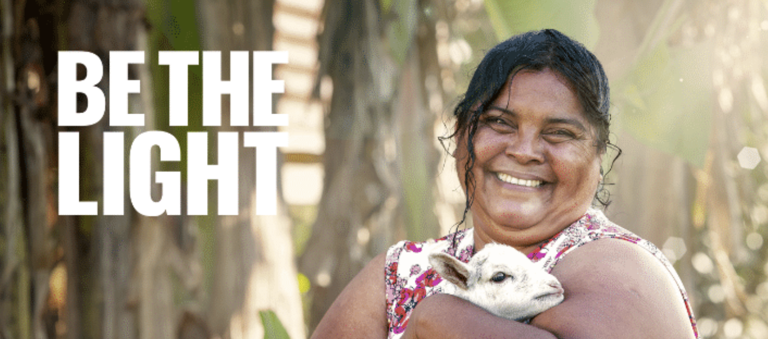 Smiling woman holding lamb